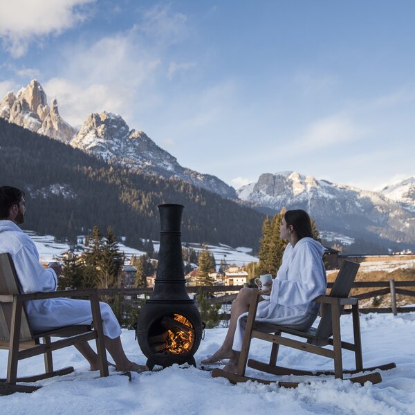 Coppia che beve il thè nel prato innevato delle QC Terme  | © QC Terme Dolomiti - Archivio Immagini ApT Val di Fassa