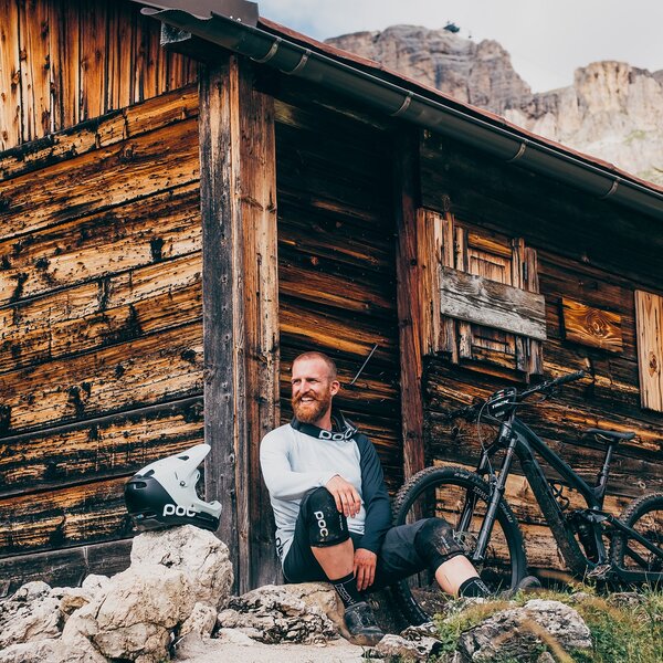 Biker che riposa vicino ad una baita | © Enduro Mag  - Archivio Immagini ApT Val di Fassa