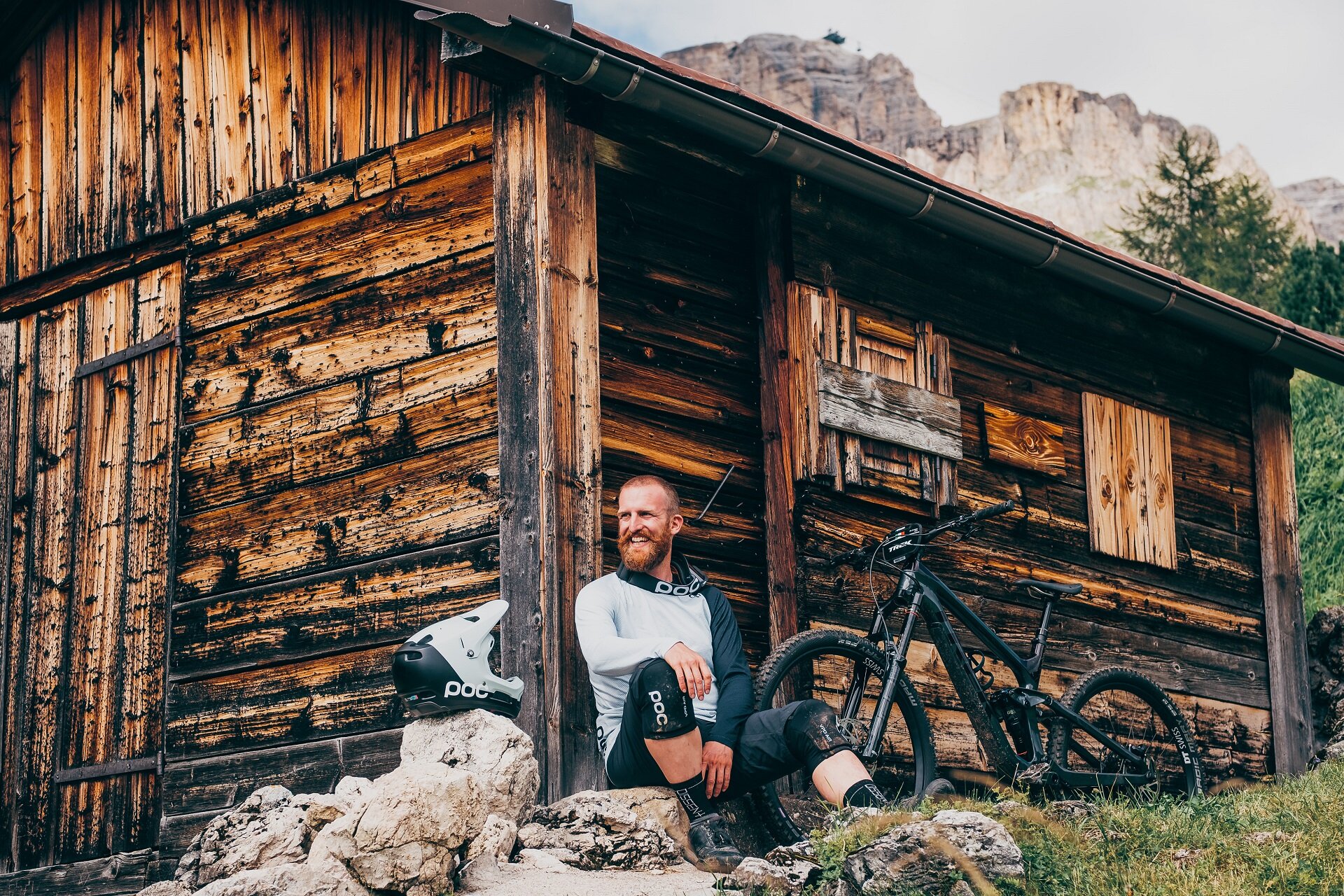 Biker che riposa vicino ad una baita | © Enduro Mag  - Archivio Immagini ApT Val di Fassa