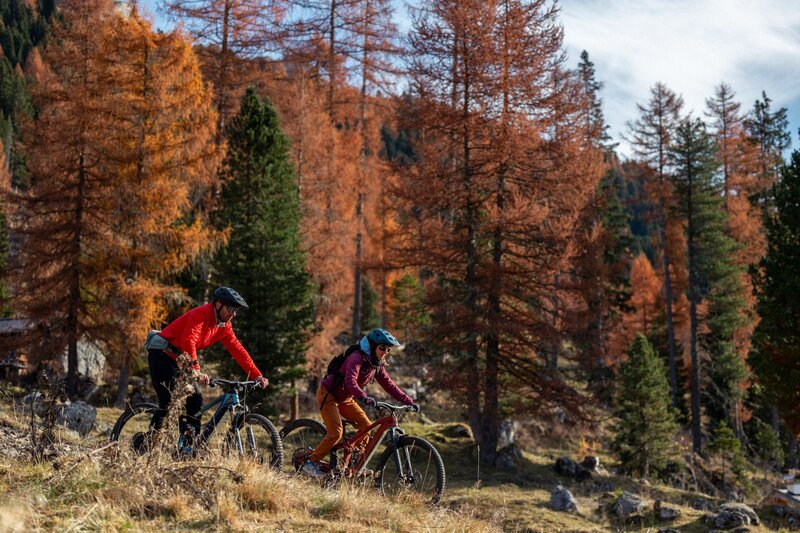 Una coppia su mountain bike tra gli alberi autunnalli della Val San Nicolò | © Archivio immagini ApT Val di Fassa  - Federico Modica