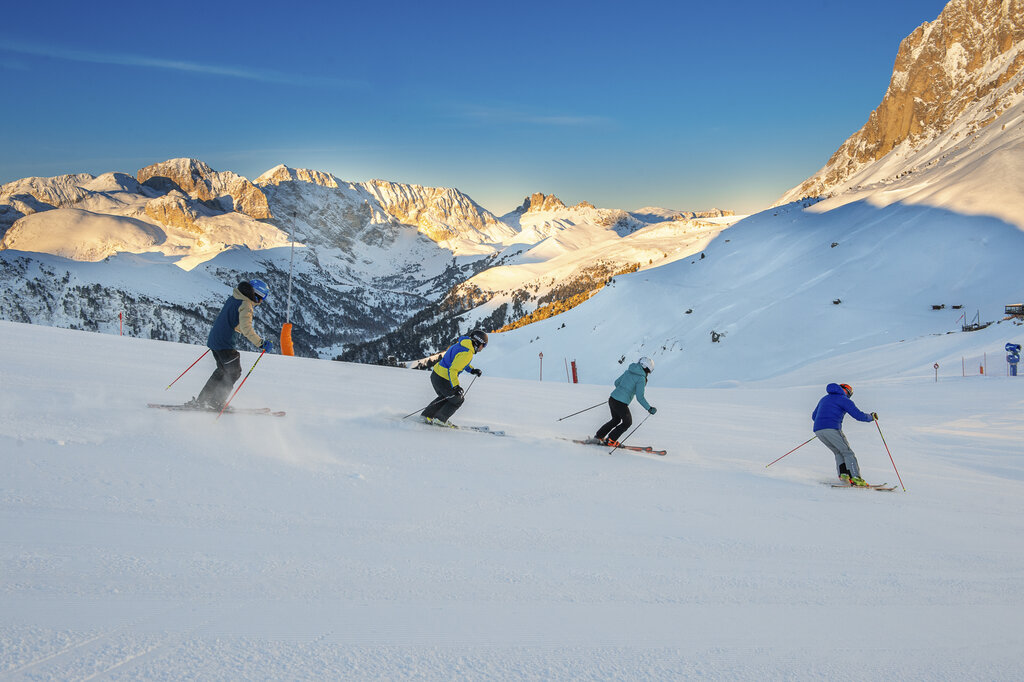 Persone che sciano all'alba sulle Dolomiti in Val di Fassa