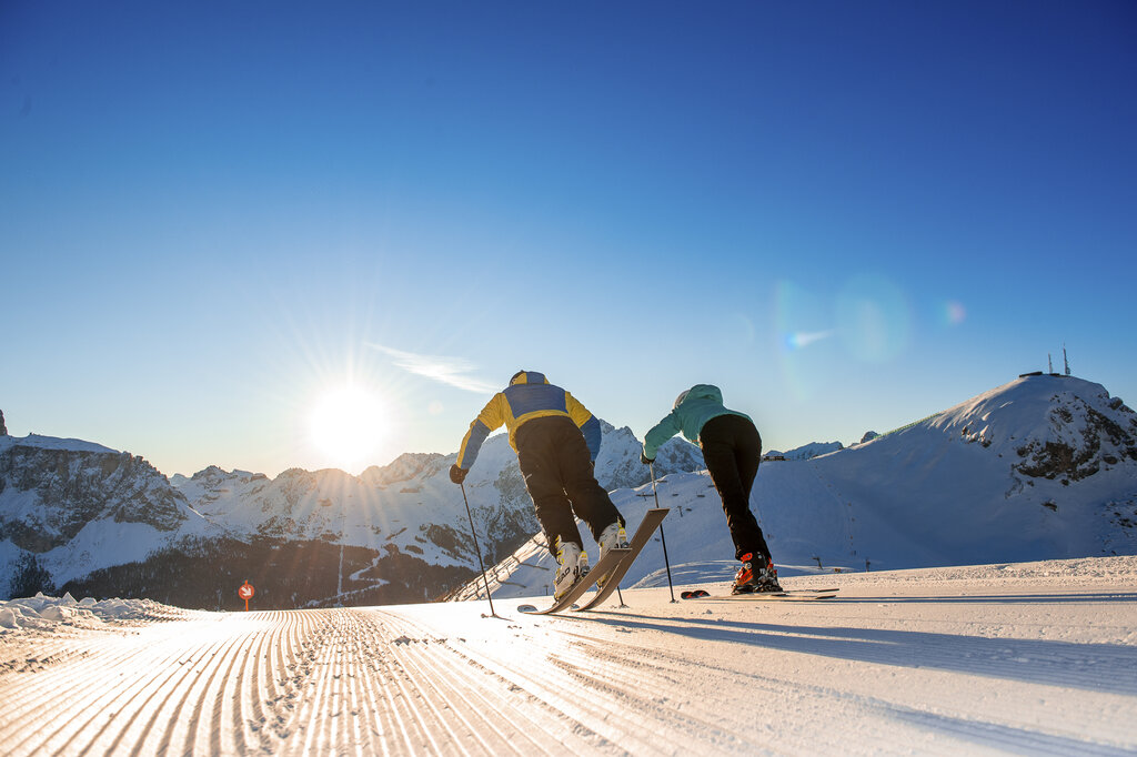 Persone che sciano all'alba sulle Dolomiti in Val di Fassa