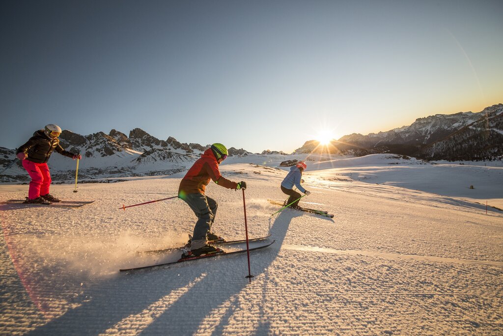 Persone che sciano all'alba in Val di Fassa