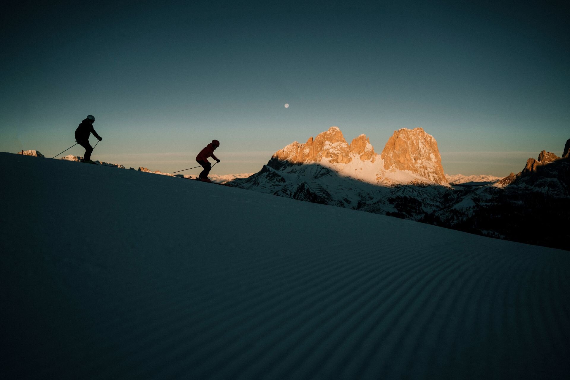 Coppia scia all'alba in Val di Fassa con vista sul Sassolungo | © Archivio immagini ApT Val di Fassa - Federico Modica
