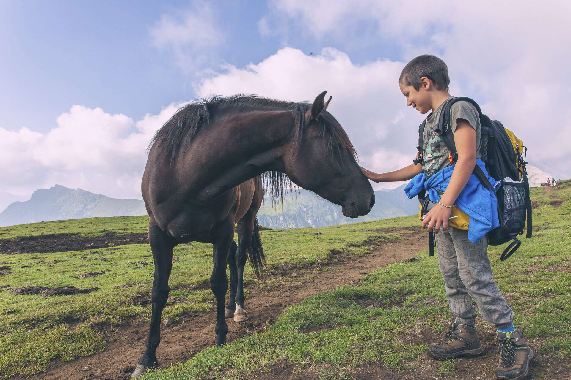 Ragazzo che saluta un cavallo in Val di Fassa | © Patricia Ramirez - Archivio Immagini ApT Val di Fassa