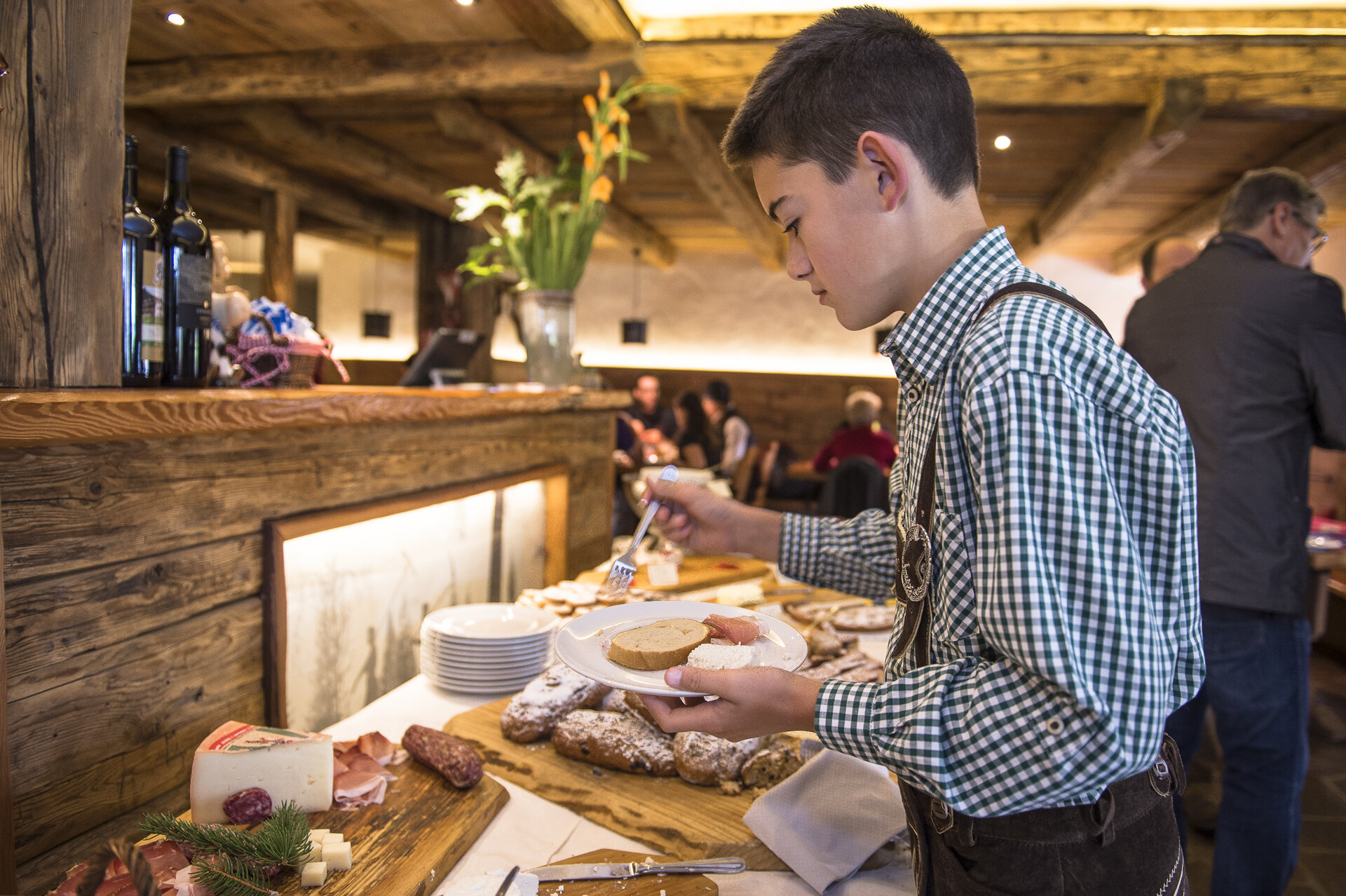 Ragazzo che si serve ad un buffet in un agriturismo in Val di Fassa | © Andrea Costa  - Archivio Immagini ApT Val di Fassa