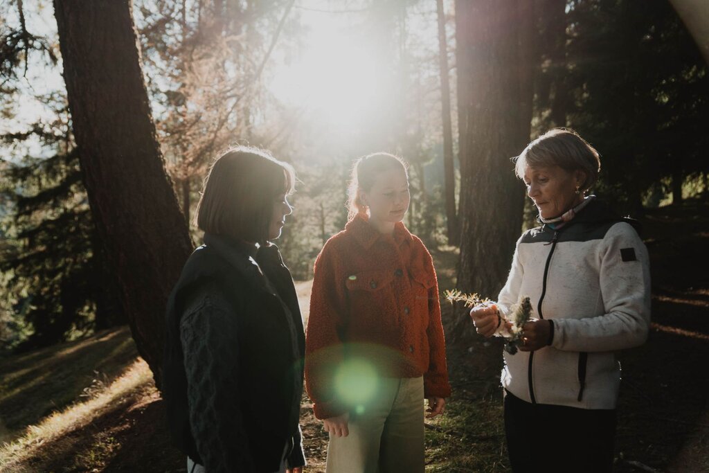 tre donne ammirano la natura in un bosco della val di fassa
