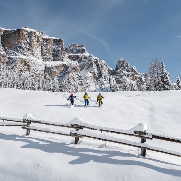 Gruppo di amici che ciaspola sotto al Sass Pordoi | © Patricia Ramirez - Archivio Immagini ApT Val di Fassa