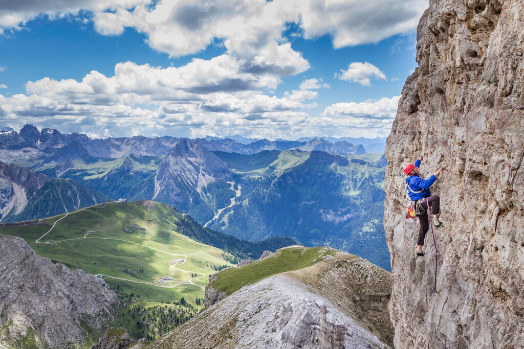 Persona che arrampica sulle pareti rocciose delle Dolomiti in Val di Fassa