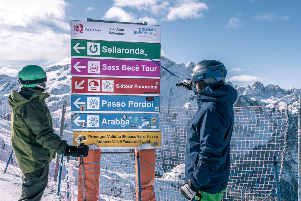 Persone che indicano il cartello dello ski tour Sellaronda
