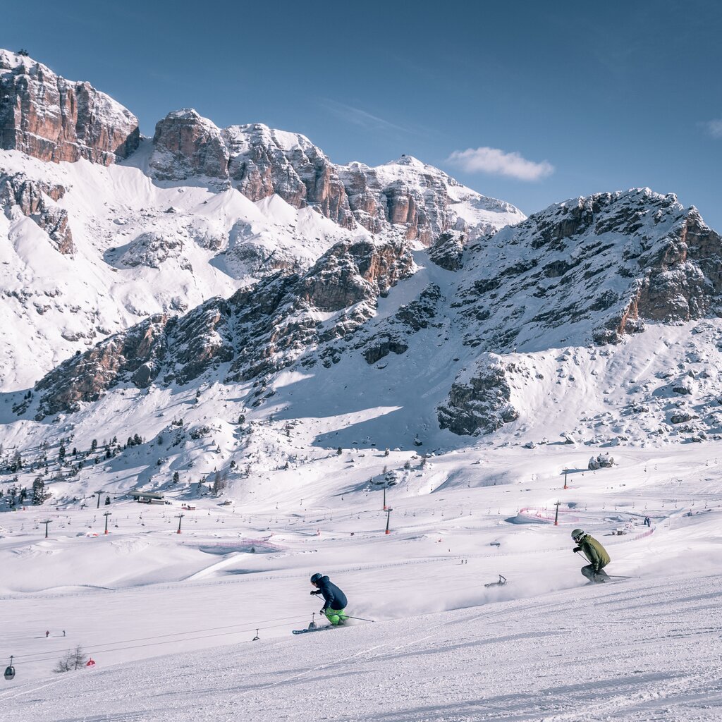 Skiarea Belvedere - Col dei Rossi - Canazei | © Patricia Ramirez  - Archivio immagini ApT Val di Fassa Coppia di amici scia sulle piste della skiarea Belvedere di Canazei. Sullo sfondo Sass Becé e Sass Pordoi | © Patricia Ramirez  - Archivio immagini ApT Val di Fassa