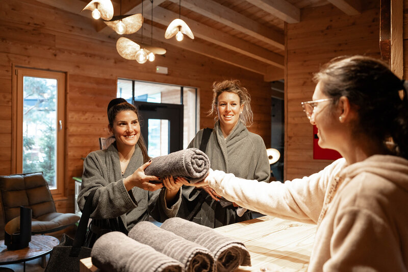 Coppia in accappatoio ritira asciugamanti alla reception di un impianto termale | &copy; Archivio immagini ApT Val di Fassa - Mattia Rizzi