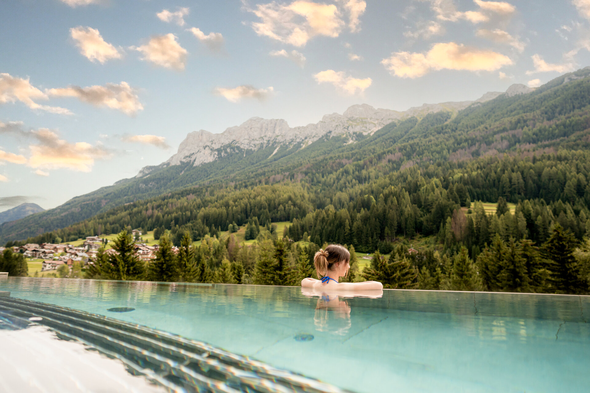 Coppia in piscina con vista sul bosco e sulle Dolomiti | © Mattia Rizzi - Archivio Immagini ApT Val di Fassa
