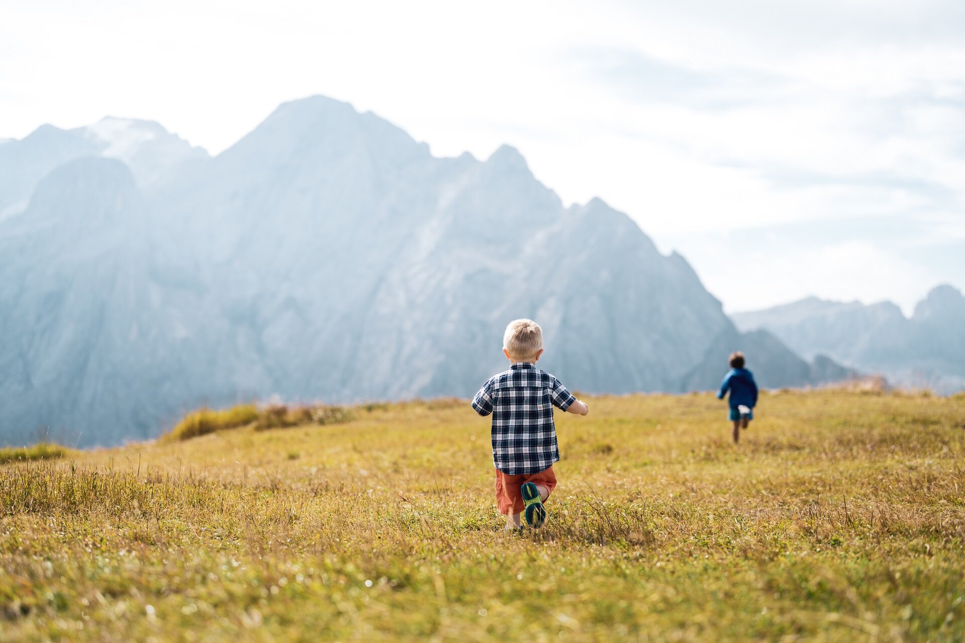 Bambini che corrono su un prato sulle Dolomiti in Val di Fassa | © Mattia Rizzi  - Archivio Immagini ApT Val di Fassa