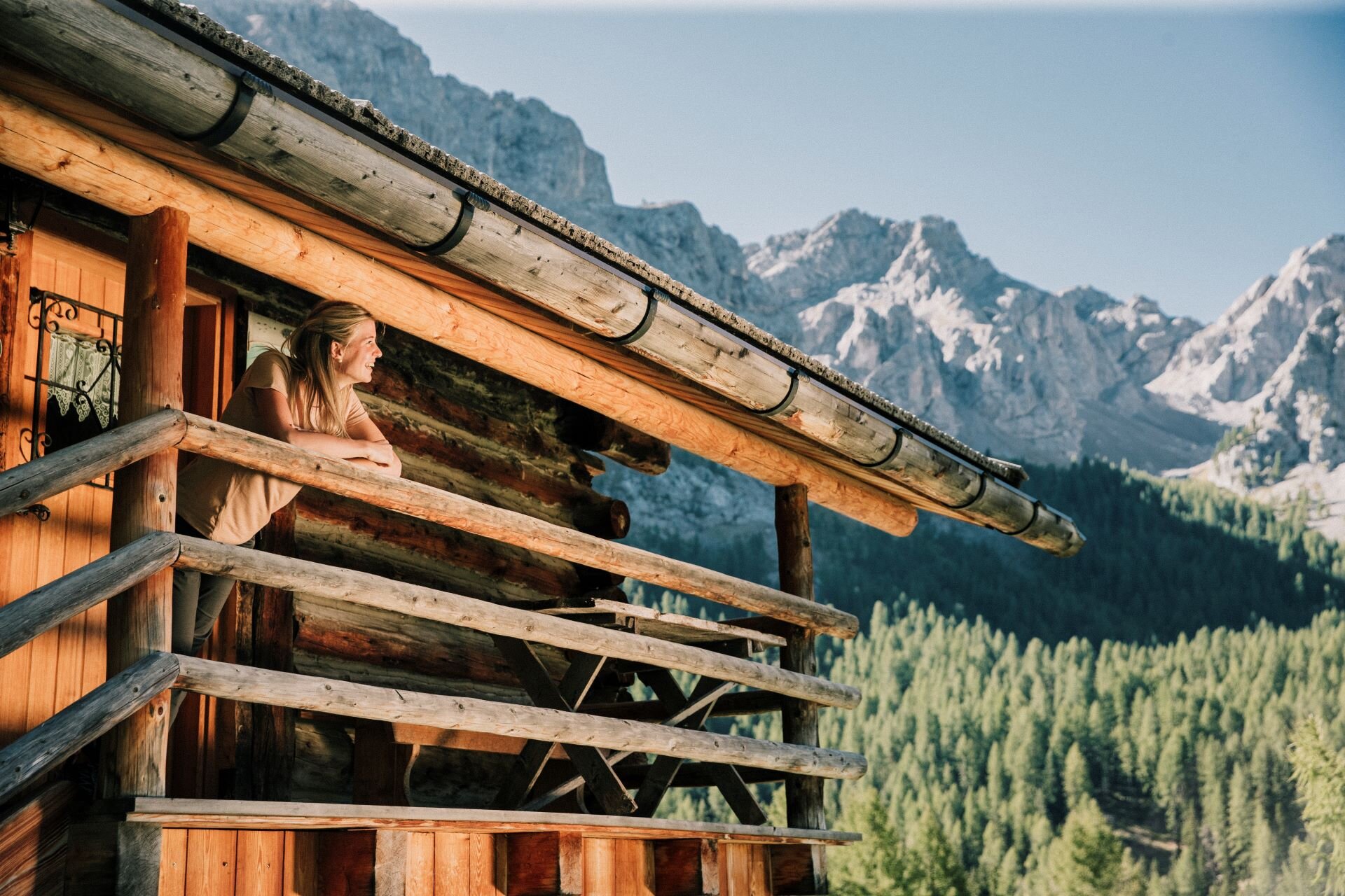 Ragazza affacciata da un balcone di una tipica baita in legno in Val di Fassa | © Federico Modica  - Archivio Immagini ApT Val di Fassa