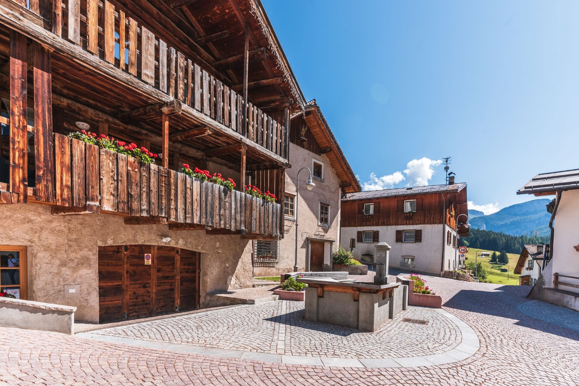 Piazzetta con lavatoio e case in legno al centro di Penìa di Canazei | © Archivio Immagini ApT Val di Fassa - Patricia Ramirez