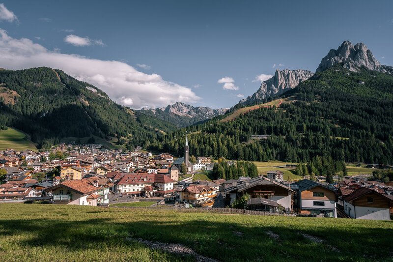 Vista dall'alto di Pozza di Fassa, sullo sfondo Cima Dodici del gruppo dei Monzoni (Dolomiti) | © Patricia Ramirez - Archivio Immagini ApT Val di Fassa