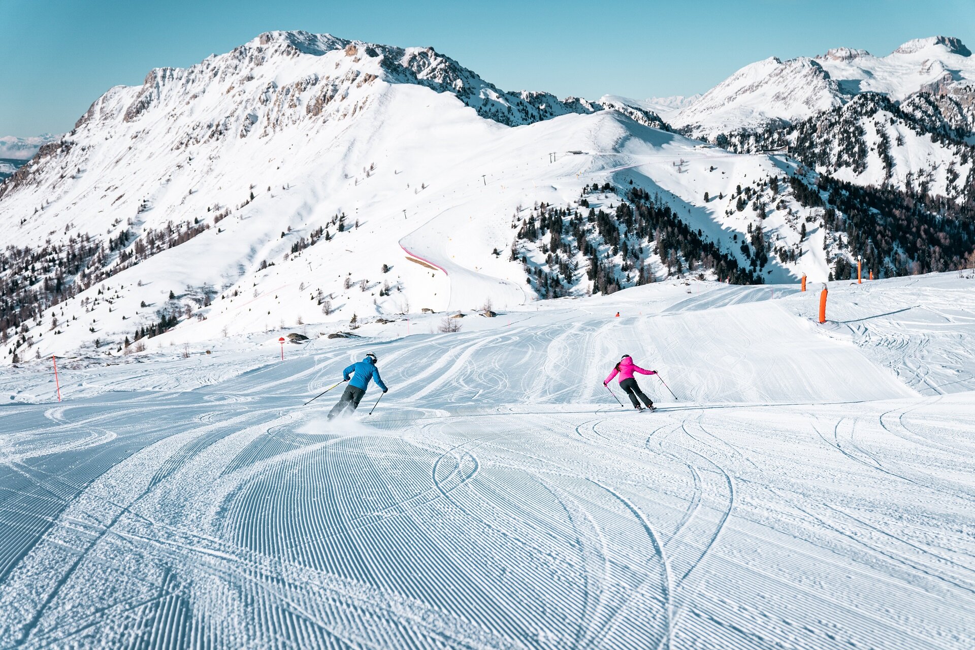 Sciatori sulle piste ai piedi delle Dolomiti nella ski area Alpe Lusia | © Camilla Pizzini - Archivio Alpe Lusia