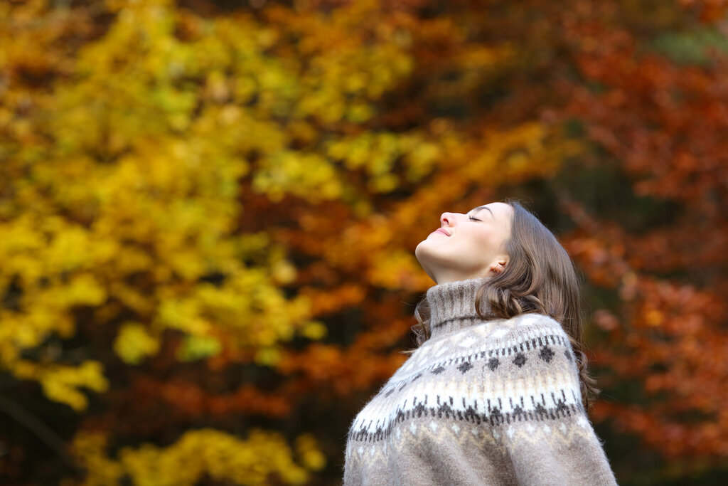 Persona che respira il benessere della natura in autunno
