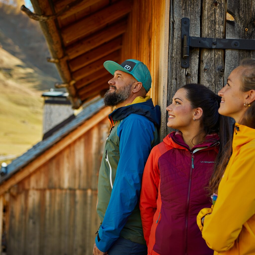 Persone che riposano fuori da una baita in autunno al Fuciade | © Fulvio Maiani Coolpixel - Archivio Immagini APT Val di Fassa