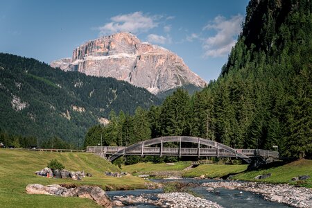 Vista da Fontanazzo, nel comune di Mazzin, di un ponte sopra il fiume Avisio. Sullo sfondo il Sass Pordoi