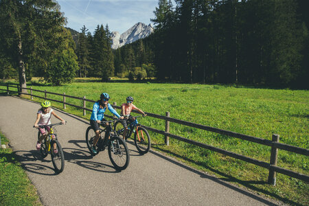 Famiglia che percorre la pista ciclabile delle Dolomiti in Val di Fassa