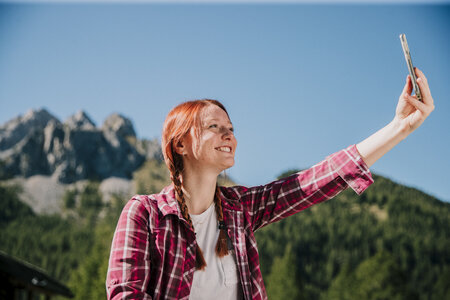 Persona che sorride felice mentre si scatta un selfie in Val di Fassa