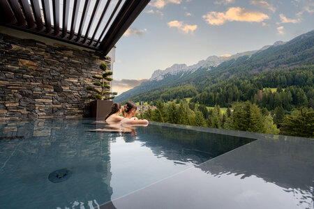 Piscina esterna con vista sulle Dolomiti in un hotel a Soraga in Val di Fassa