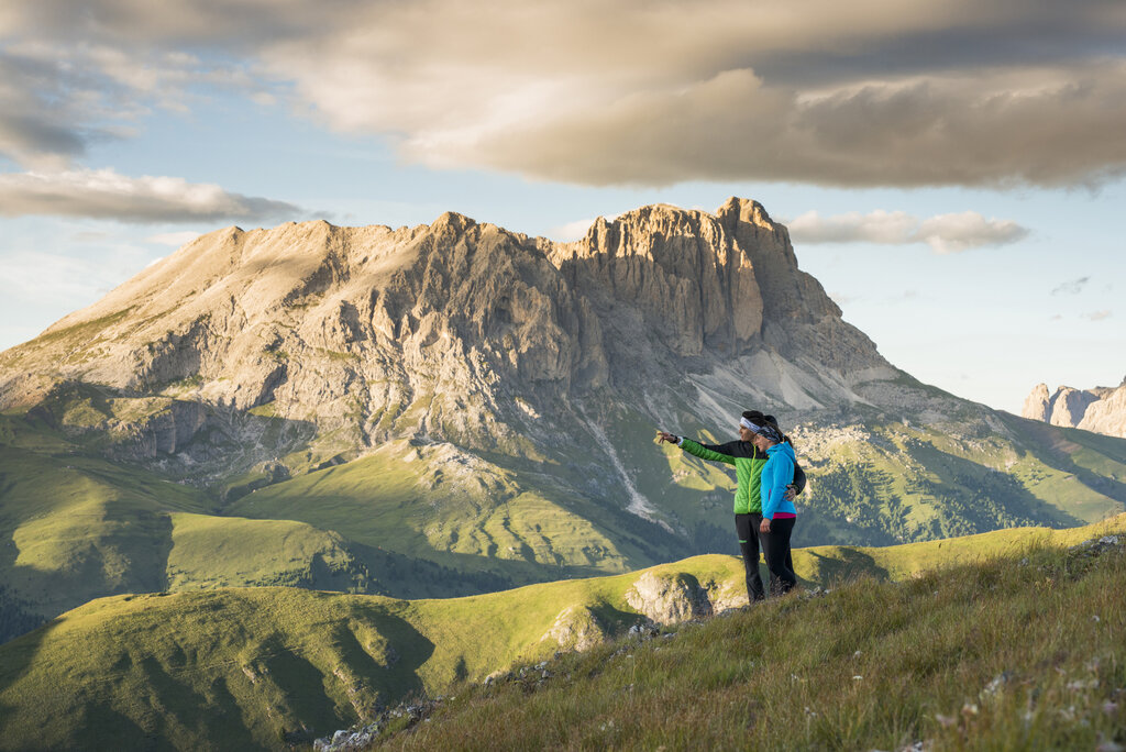 Persone ferme ad ammirare le Dolomiti in un trekking in Val di Fassa